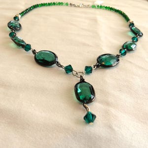 necklace of various sizes and shapes of bright green crystal beads with silver accents