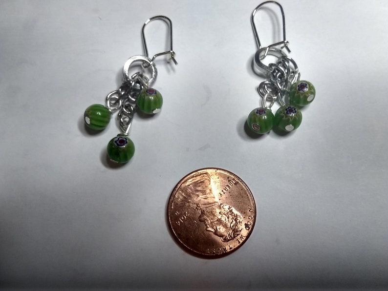 very cute Earrings with dangling round green beads with 3 with red and blue accents