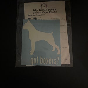 May include: A light blue vinyl decal featuring a Boxer dog silhouette, with the text "got boxers?" in white. The decal is packaged with application instructions from "My Triple Force Custom Vinyl Decals".