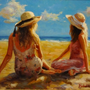 May include: Two women wearing straw hats sit on a sandy beach, facing the ocean. The woman on the left is wearing a floral dress, while the woman on the right is wearing a pink dress. The sky is blue with white clouds.