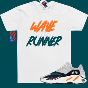 May include: White t-shirt with "WAVE RUNNER" written in orange and green paint. A pair of grey, black, and orange sneakers with a yellow accent.