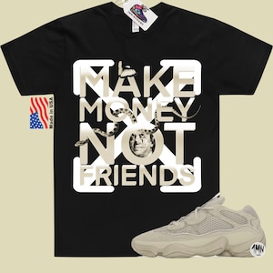 K&ouml;nnte beinhalten: Schwarzes T-Shirt mit einer wei&szlig;en Grafik, auf der "Make Money Not Friends" steht, mit einer Schlange und einem Schmetterling auf der Grafik. Das Shirt wird mit beigen Sneakern mit Mesh-Design kombiniert.