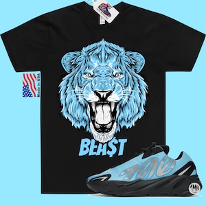 May include: Black t-shirt with a blue lion graphic and the word "BEAST" printed on it. A pair of blue and black sneakers with the number "700" printed on the side.