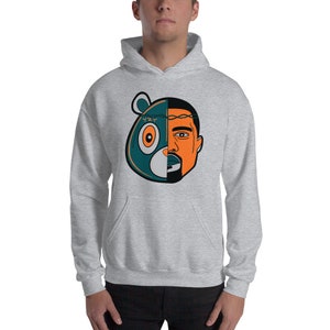 May include: A grey hoodie featuring a graphic of a blue and green bear head with a crown of thorns and Kanye West's face on the right side of the bear's head. The graphic has the text "YZY" on the bear's forehead.