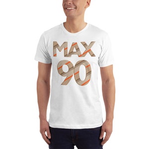 May include: White t-shirt with a brown and orange striped design that says "MAX 90" on the front.