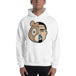 May include: White hooded sweatshirt featuring a graphic print of a cartoon bear and a man's face. The bear's face is on the left side of the graphic and the man's face is on the right side. The bear has a brown nose, brown fur, and a black eye. The man has a brown beard, brown hair, and blue lips.