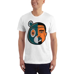 May include: White t-shirt with a graphic of a blue and green bear head with the word "YZY" on the forehead, and the right half of the bear's face is replaced with a man's face with a crown of thorns.