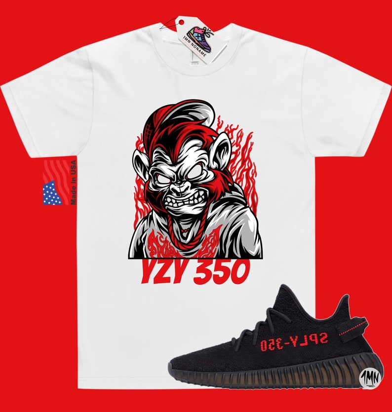 May include: White t-shirt with a red and black illustration of a monkey wearing a hat and a chain. The text "YZY 350" is printed below the monkey. Black and red sneakers with the text "YZY 350" on the side.