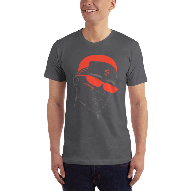 May include: A dark gray t-shirt with a red illustration of a person wearing a red hat with a dollar sign and red sunglasses. The text "SOMED" is written on the sunglasses.