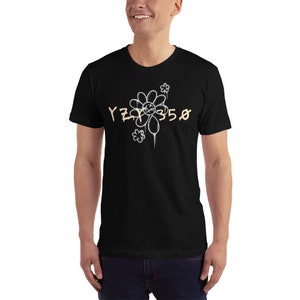 Pode incluir: Camiseta preta com um gr&aacute;fico de margarida branca e o texto "YZY 350" em uma cor marrom clara.
