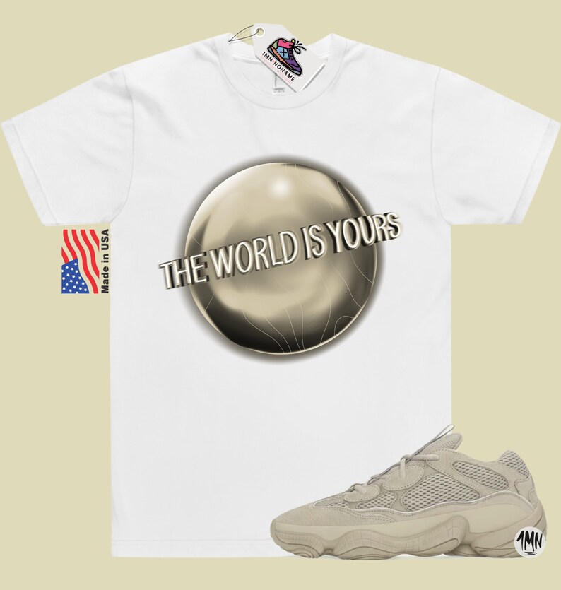 May include: White t-shirt with a gold sphere graphic and the text "The World Is Yours". A pair of beige sneakers with a mesh upper and a thick sole are also pictured.