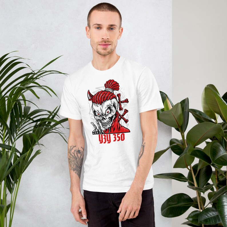 Op de afbeelding: Wit T-shirt met een rode en zwarte schedelprint. De schedel heeft rode dreadlocks en hoorns. De tekst "93Y 350" is onder de schedel gedrukt.