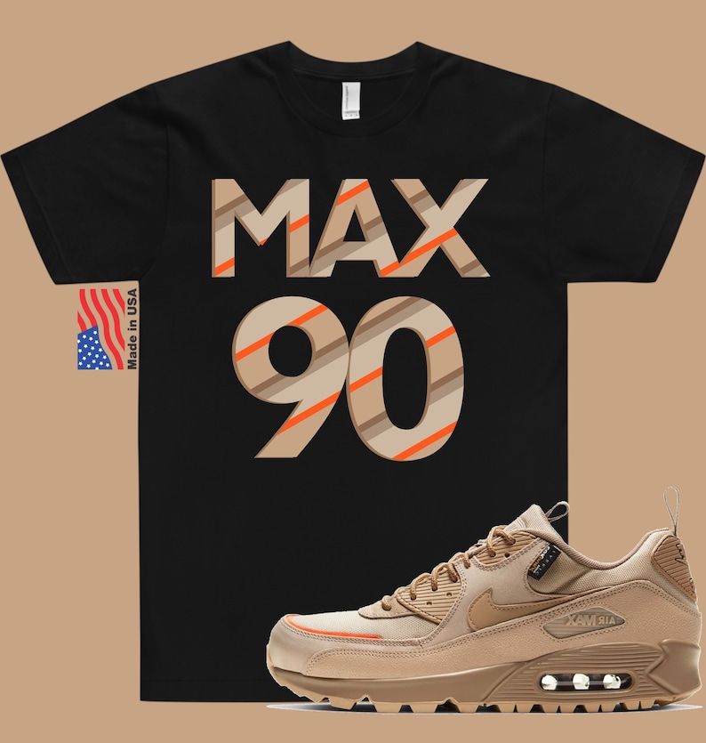 May include: Black t-shirt with the text "MAX 90" in brown and orange stripes. A pair of tan Nike Air Max 90 trainers with orange accents.