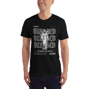 May include: Black t-shirt with a graphic print of a winged angel statue and the text "Blessed" repeated four times. The text "Guardian of Death" is also printed on the shirt.
