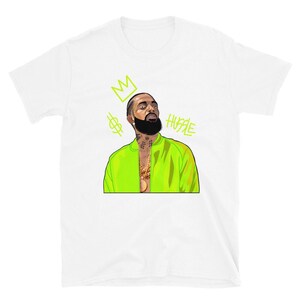 Puede incluir: Camiseta blanca con una ilustraci&oacute;n verde de un hombre que lleva una chaqueta verde y una cadena de oro. La ilustraci&oacute;n incluye una corona, un signo de d&oacute;lar y la palabra "HUSTLE".