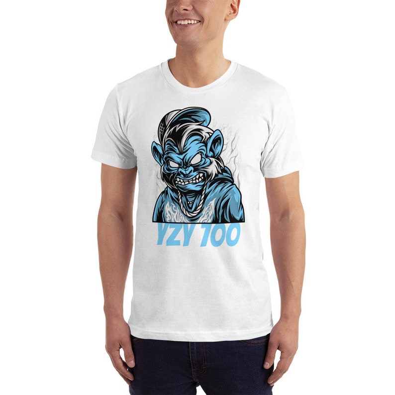 May include: White t-shirt with a blue cartoon illustration of a monkey wearing a hat and a chain. The text "YZY 100" is printed in blue below the illustration.
