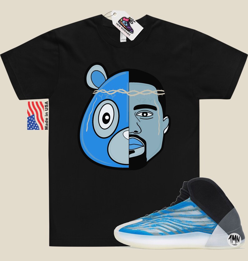 May include: Black t-shirt with a blue and grey illustration of a bear head and a man's face. The text "1MN" is on the side of a blue and white sneaker.