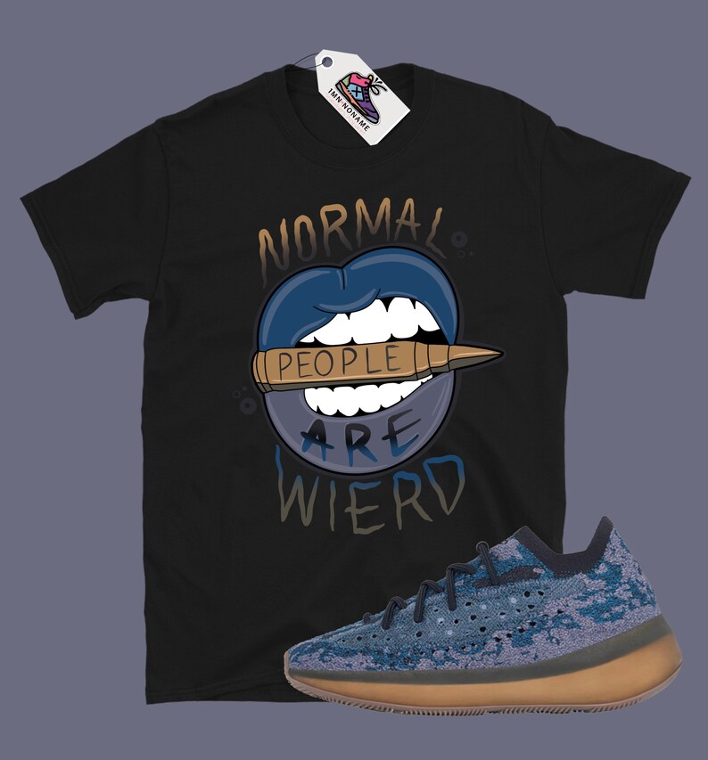 Op de afbeelding: Zwart T-shirt met een afbeelding van een blauwe mond met een kogel waarop "people" staat en de tekst "Normal People Are Wierd". Er is ook een paar blauwe en bruine sneakers te zien.