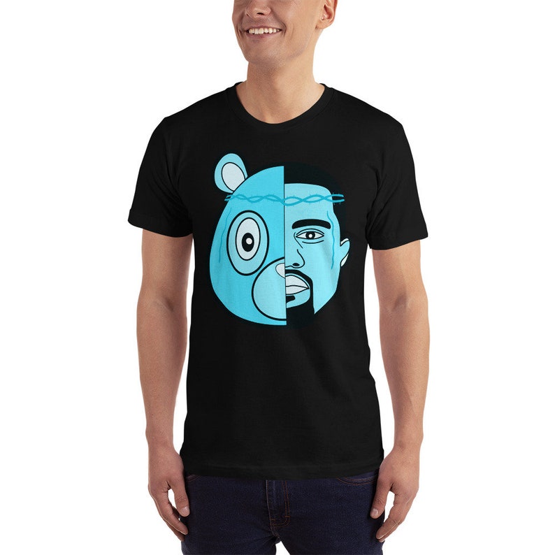 May include: A black t-shirt with a graphic of a blue cartoon bear with a crown of thorns and a man's face on the right side of the bear's face.