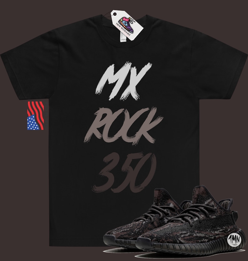 Puede incluir: Camiseta negra con el texto "MX ROCK 350" en blanco, gris y negro en pinceladas. Un par de zapatillas negras y grises con estampado de camuflaje se encuentran en la esquina inferior derecha de la imagen.