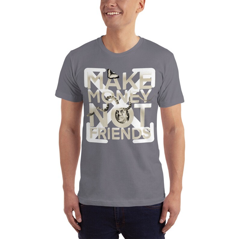 K&ouml;nnte beinhalten: Ein graues T-Shirt mit einem wei&szlig;en Grafikdesign, auf dem "MAKE MONEY NOT FRIENDS" steht. Das Grafikdesign zeigt einen Schmetterling, eine Schlange und ein menschliches Gesicht.