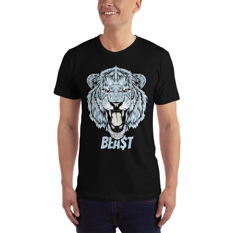 Peut inclure: T-shirt noir avec une illustration bleue et blanche d'une t&ecirc;te de lion rugissant et le mot "BEAST" imprim&eacute; en dessous.