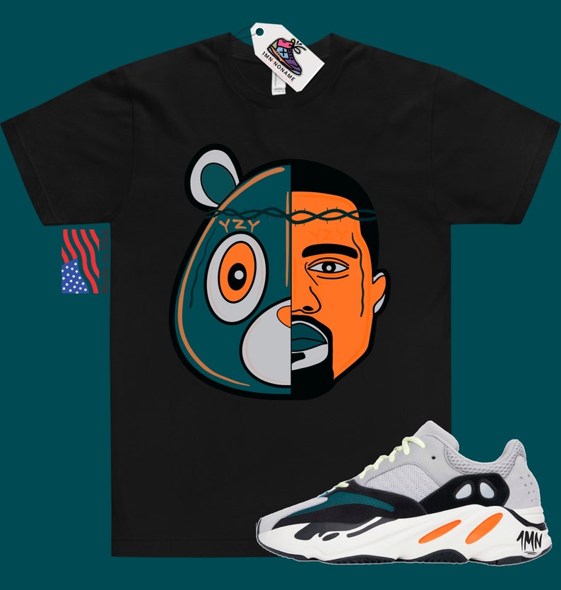 May include: Black t-shirt with a graphic of Kanye West's face and the Yeezy bear logo. The graphic is split in half, with Kanye's face on the right and the bear on the left. The bear is teal and orange, and Kanye's face is orange. The t-shirt is paired with a pair of white, orange, and teal sneakers with the text "YZY" on the side.
