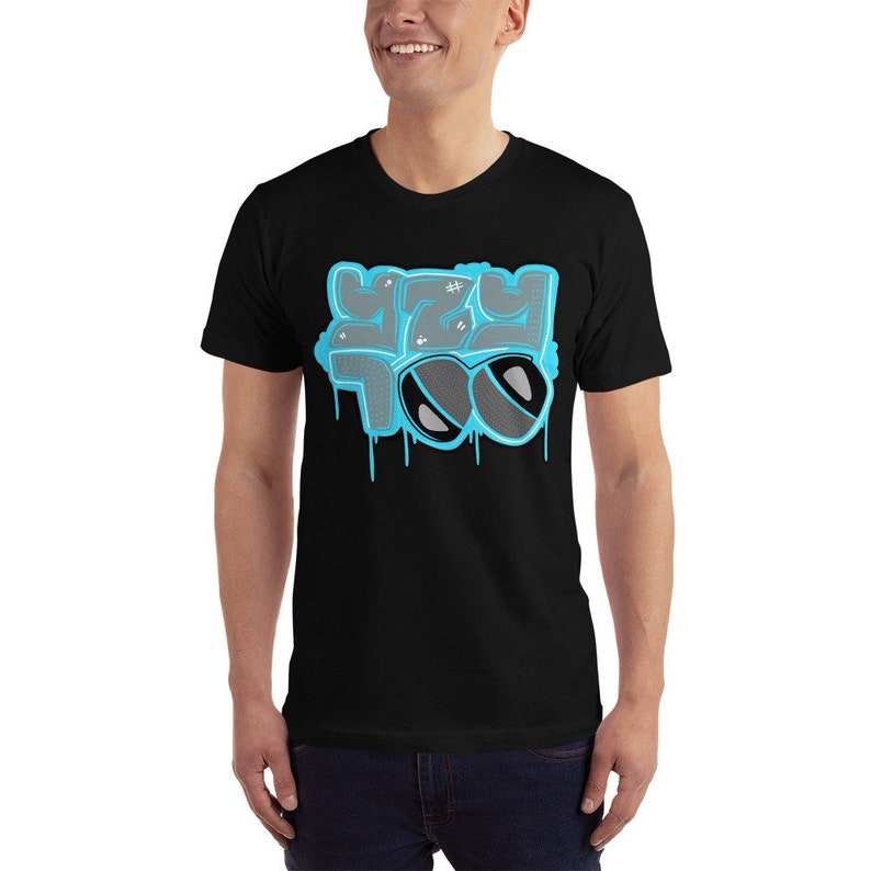 May include: Black t-shirt with a blue and gray graphic of the words "Yeezy Too" with sunglasses.