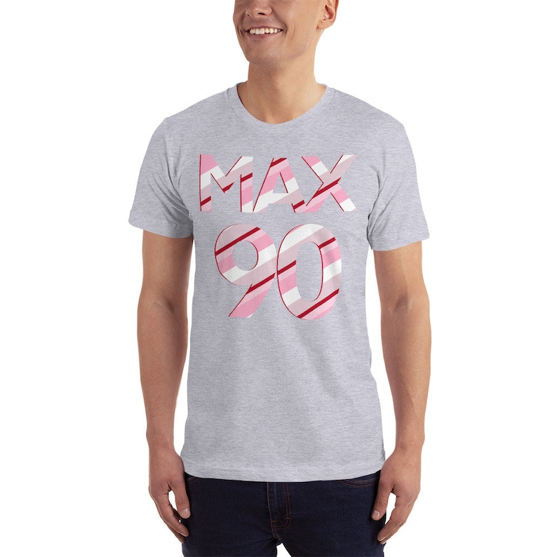 May include: A gray t-shirt with a pink and red striped design that says "MAX 90" on the front.