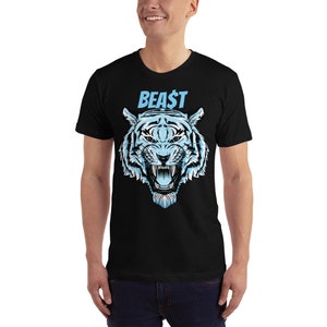 以下が含まれることがあります： 青い文字で「BEAST」と書かれた、青と白の虎のグラフィックがプリントされた黒いTシャツ