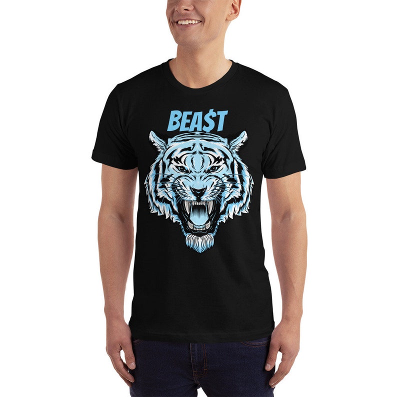 以下が含まれることがあります： 青い文字で「BEAST」と書かれた、青と白の虎のグラフィックがプリントされた黒いTシャツ