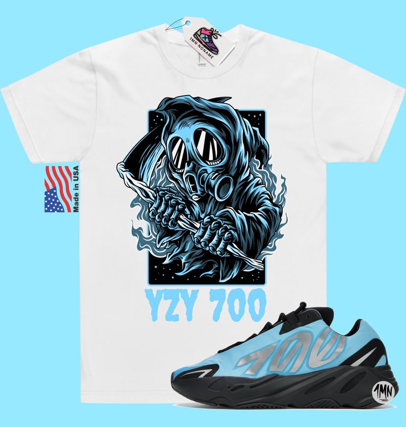 May include: White t-shirt with a blue graphic of a hooded figure wearing a gas mask and holding a scythe. The text "YZY 700" is printed below the graphic. A pair of blue and black Yeezy 700 sneakers are shown below the t-shirt.