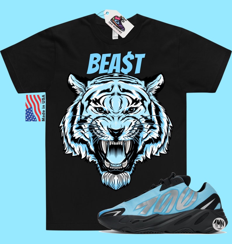以下が含まれることがあります： 青い虎のグラフィックと青い「BEAST」の文字が書かれた黒いTシャツ。側面に「700」の数字が書かれた青と黒のスニーカーのペア。