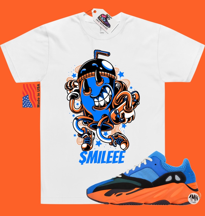 May include: White t-shirt featuring a cartoon illustration of a blue and orange drink with a straw and the text "$MILEEE". A pair of blue and orange trainers with black accents are also shown.