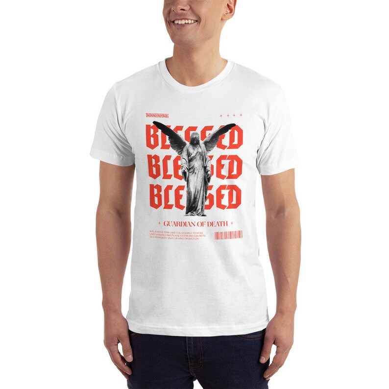 May include: White t-shirt with a red graphic print of an angel with wings and the word "Blessed" repeated four times. The text "Guardian of Death" is printed below the angel.