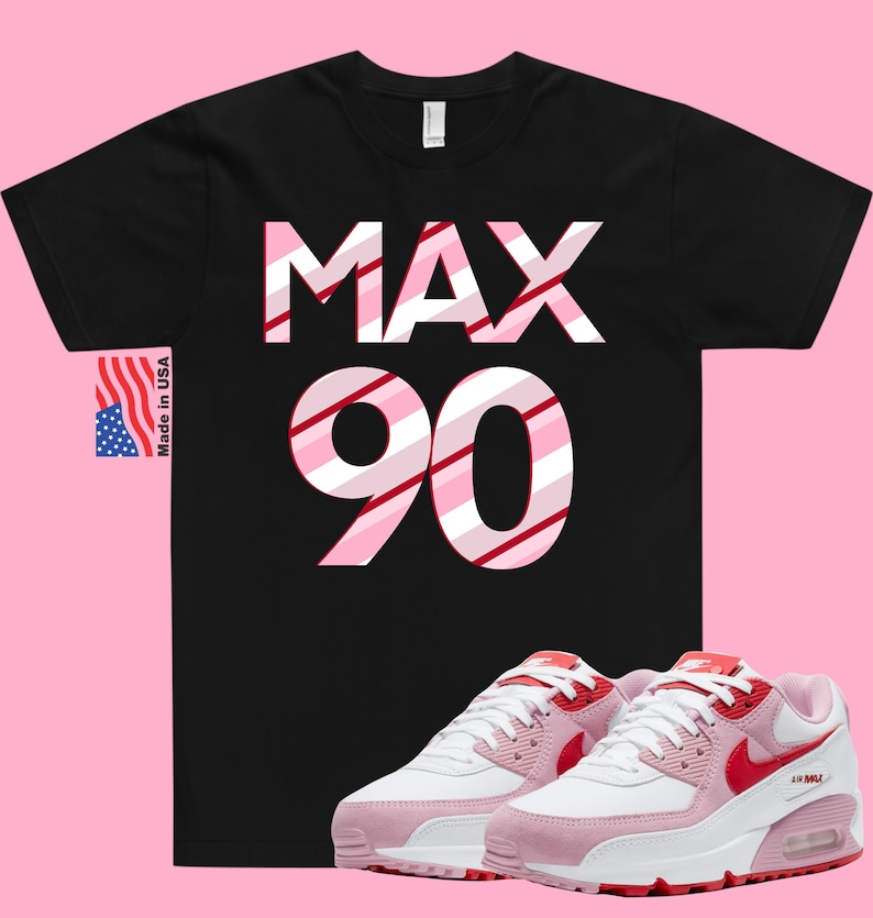 May include: Black t-shirt with "MAX 90" in pink and red stripes. Pink and white sneakers with red accents and a white swoosh logo.
