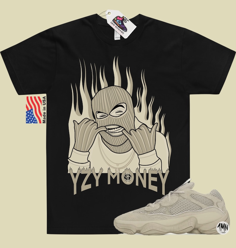 May include: Black t-shirt with a graphic of a masked figure with flames behind them. The text "YZY MONEY" is printed below the figure. A pair of beige sneakers are also pictured.