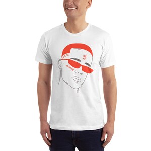 May include: White t-shirt with a red and gray illustration of a person wearing red sunglasses and a red hat with a dollar sign on it. The text "money" is written on the person's face.