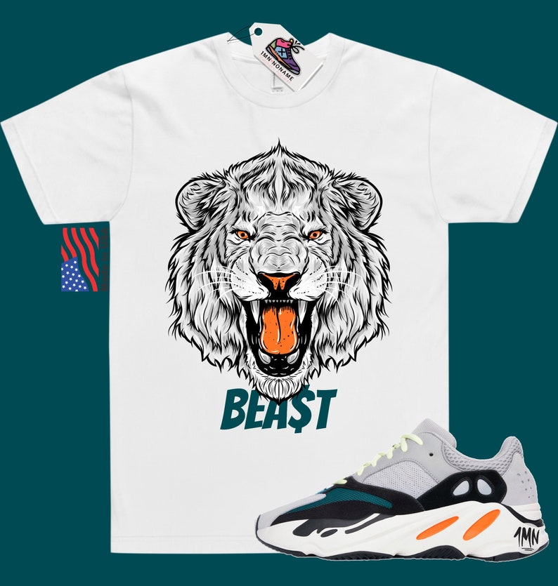 May include: White t-shirt featuring a graphic of a roaring lion's head with the word "BEAST" printed beneath. A pair of grey, black and orange trainers are shown below the shirt.