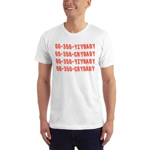 Peut inclure: T-shirt blanc avec le texte "00-350-YZBABY 00-350-CRYBABY 00-350-YZBABY 00-350-CRYBABY" imprim&eacute; en rouge.