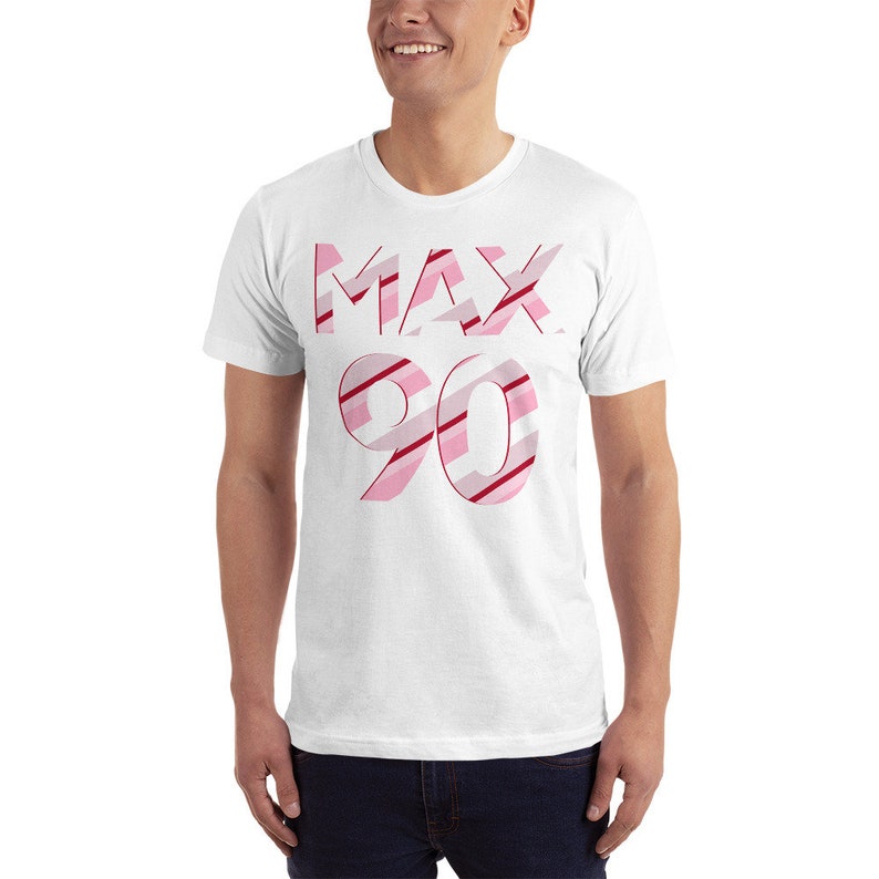 May include: White t-shirt with a pink and red striped design that says "MAX 90" on the front.