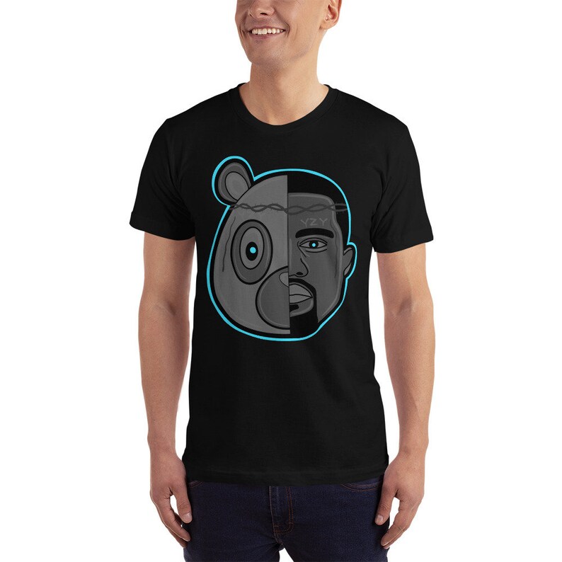 Op de afbeelding: Zwart T-shirt met een afbeelding van een grijs berenhoofd en een mannengezicht, gesplitst in het midden. De beer heeft een blauw oog en de man heeft een blauw oog. De afbeelding is omrand met blauw. De tekst "YZY" is zichtbaar op het voorhoofd van de man.