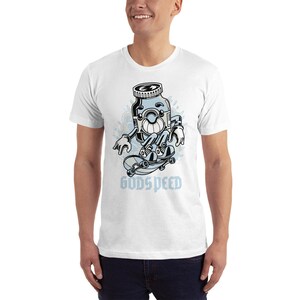 K&ouml;nnte beinhalten: Wei&szlig;es T-Shirt mit einer Cartoon-Illustration eines Glases mit einem Gesicht, das Skateboard f&auml;hrt. Das Glas tr&auml;gt eine schwarze M&uuml;tze und hat ein blaues und wei&szlig;es Skateboard. Der Text "GODSPEED" ist unter dem Glas gedruckt.