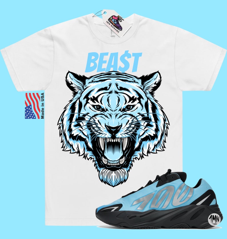 以下が含まれることがあります： 青い虎のグラフィックと青い文字で「BEAST」と書かれた白いTシャツ。側面に「700」と記された黒と水色のスニーカーのペア。