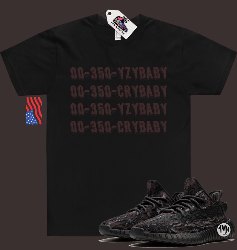 Puede incluir: Camiseta negra con el texto "00-350-YZYBABY" y "00-350-CRYBABY" repetido dos veces. Un par de zapatillas negras y grises con estampado de camuflaje.