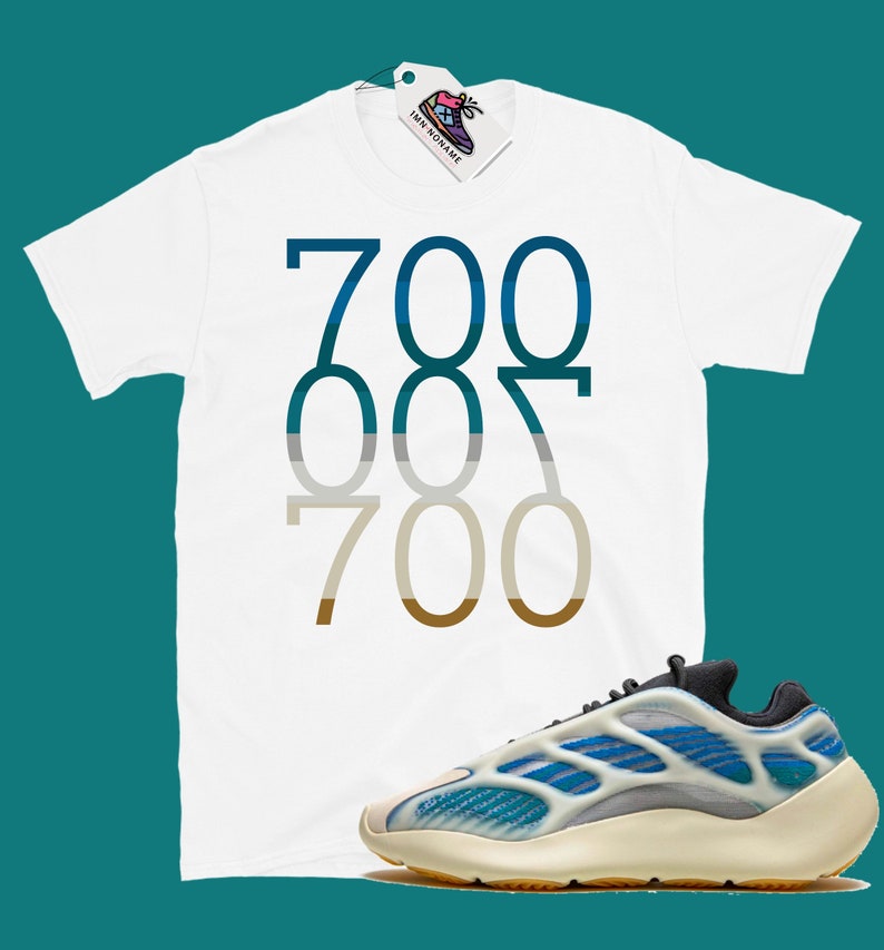 May include: White t-shirt with the numbers 700, 007, and 700 printed in a gradient of blue, grey, and brown. A pair of white and blue trainers with a black sole.