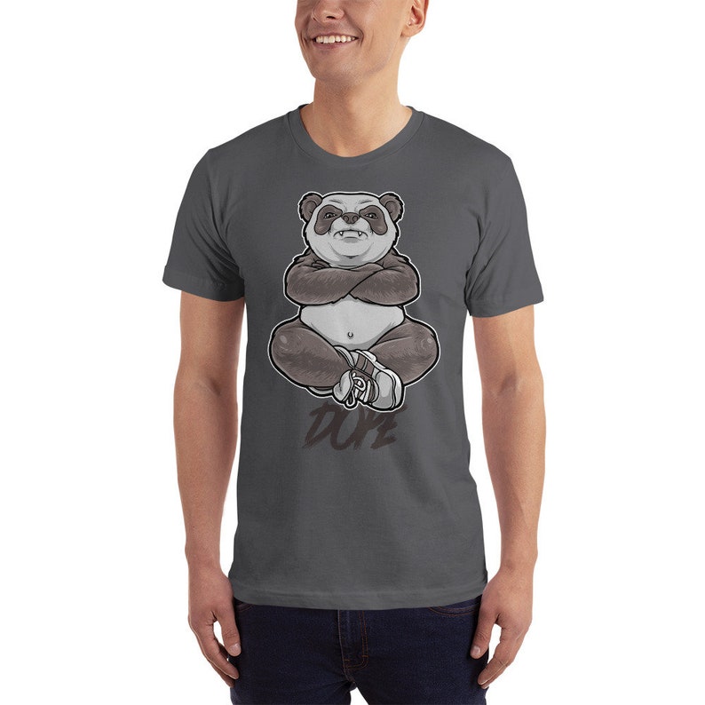 Peut inclure: Un t-shirt gris fonc&eacute; avec un panda dessin anim&eacute; portant des baskets et assis les bras crois&eacute;s. Le panda est blanc et gris avec des yeux noirs et un nez noir. Le texte "DOPE" est imprim&eacute; sous le panda.