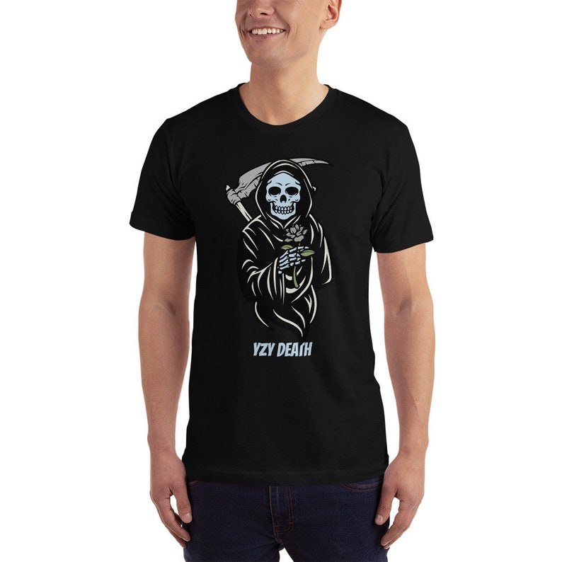 May include: A black t-shirt featuring a graphic of a blue skeletal figure in a black robe holding a flower. The figure is holding a scythe in its other hand. The text "VZY DEATH" is printed below the figure.