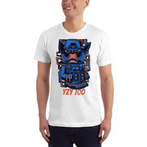 Puede incluir: Camiseta blanca con un gr&aacute;fico azul y naranja de un animal de dibujos animados con un sombrero y sosteniendo una radio. El texto "YZY 700" est&aacute; impreso debajo del gr&aacute;fico.