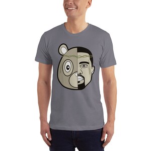 May include: A gray t-shirt with a graphic of a cartoon bear and a man's face. The bear's face is on the left side of the graphic and the man's face is on the right side. The bear is wearing a crown of thorns.